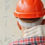 South Florida construction worker holding neck in pain
