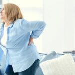 An educational poster titled 'Middle Back Pain: Causes and Relief' depicting the anatomy of the middle back and highlighting common causes of pain in that area. The poster includes text and visual aids to explain symptoms and potential treatments.