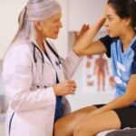 Female student athlete consulting with doctor