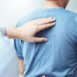gentle chiropractor touching patients back