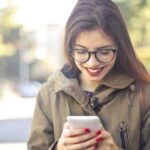 Woman looking at posture apps on her smartphone.