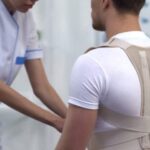 Man wearing posture brace at chiropractor's office.