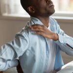 Man grabbing shoulder and neck in pain
