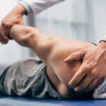 Chiropractor adjusting patient's shoulder.