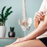 Woman giving herself a massage on the arm with a soft tissue therapy tool.