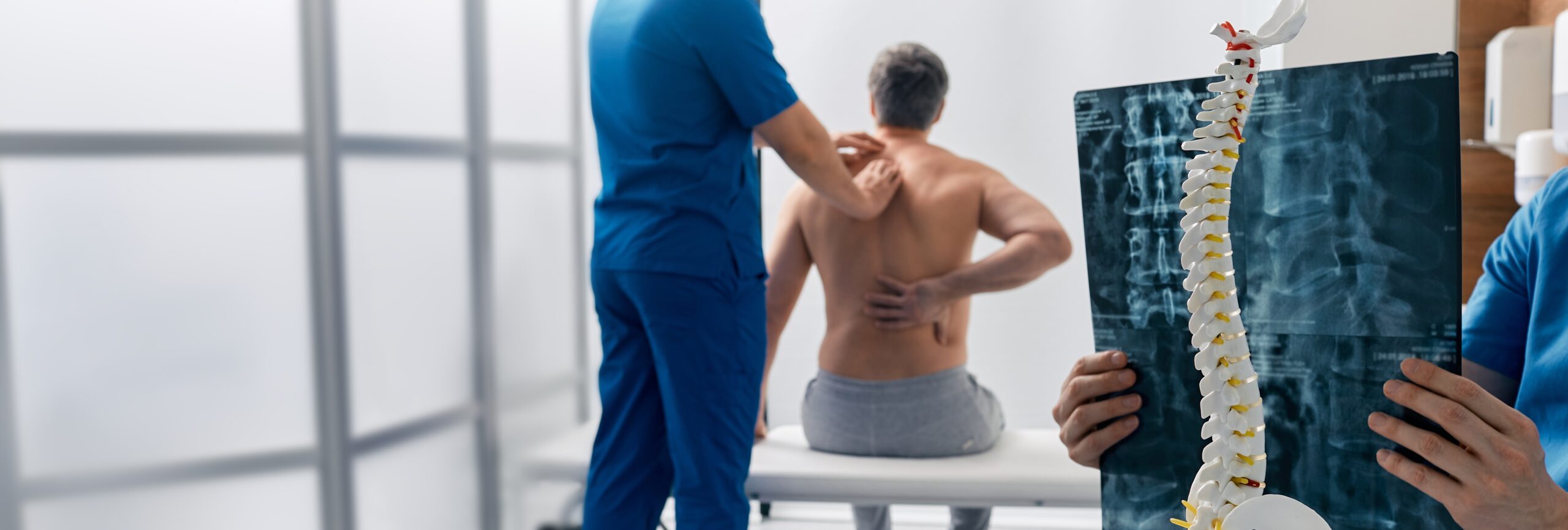 Chiropractor examining patient with spine pain.