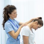 Chiropractor performing a neck and shoulder adjustment on a patient in a clinical setting.