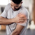 A man with shoulder pain is visiting a chiropractor.