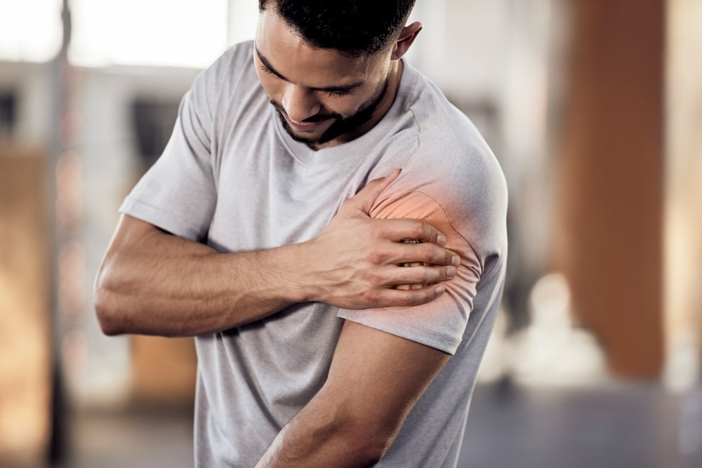 A man with shoulder pain is visiting a chiropractor.