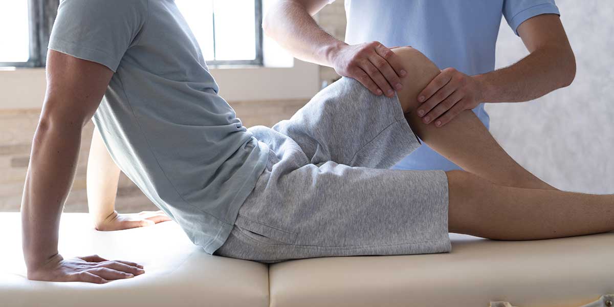 A therapist examines a patient's leg during a professional knee pain treatment session at a clinic in Weston, FL.