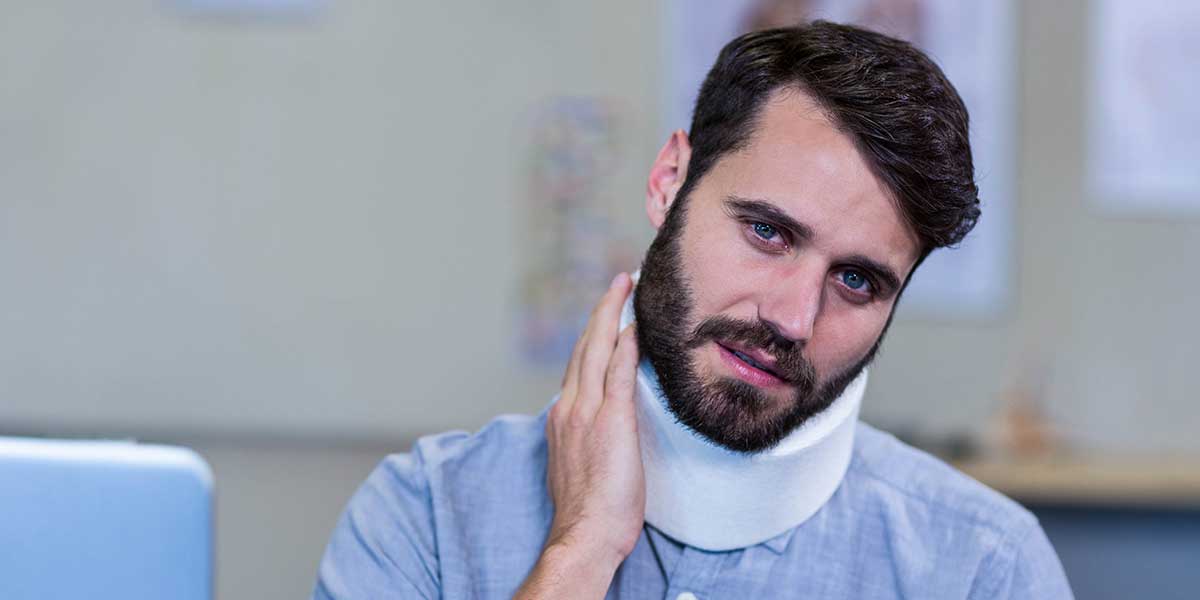 A man wearing a white cervical neck brace, illustrating how long it takes to recover from a whiplash injury.