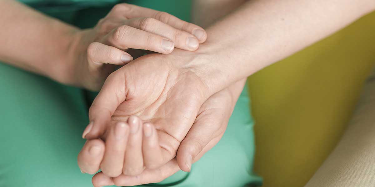 A medical professional gently examining a patient's hand and wrist for carpal tunnel treatment in Plantation, FL.