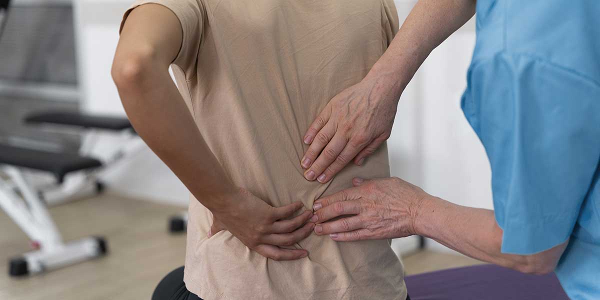 A healthcare provider examining a patient's lower back for herniated and bulging disc relief in Port St. Lucie, FL.