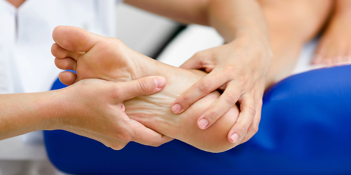 Physical therapist performing ankle pain treatment and hands-on foot therapy for a patient in Coral Springs, FL.